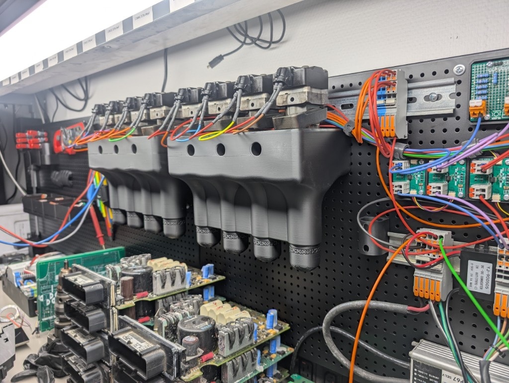 Bench validation setup with injector test fixtures and electronics on pegboard