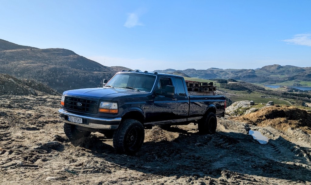 Blue Ford F-250 OBS personal vehicle on field roads
